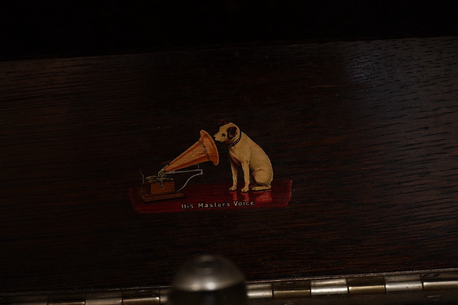 Two gramophone players; an oak cased HMV tabletop gramophone on a similar style mahogany gramophone record stand, height of stand 72.5cm, together with a May-Fair Deluxe Model portable gramophone player. Condition - poor